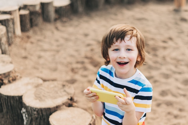 Niño con teléfono afuera