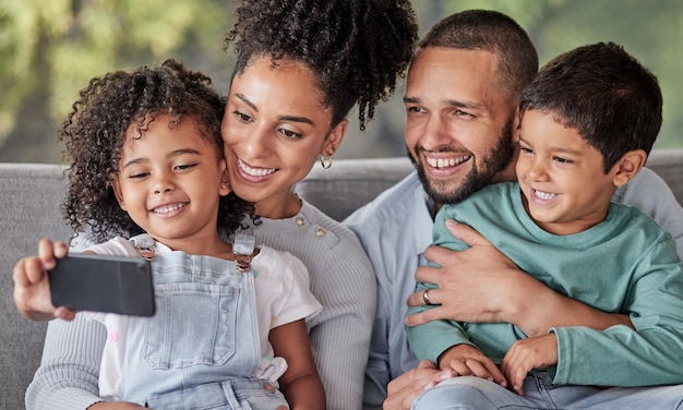 Niño con teléfono inteligente para selfie de retrato familiar en el sofá con madre y padre para redes sociales o galería digital en línea Felicidad amor y tiempo de calidad con madre padre e hijo tomando fotos