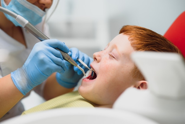 Niño teniendo sus dientes examinados por un dentista