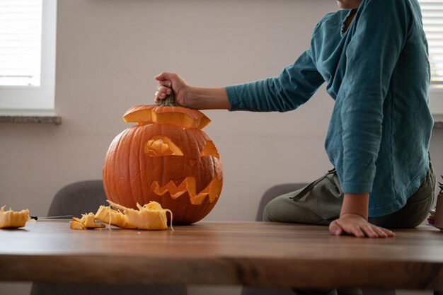 Niño terminando una calabaza casera de halloween