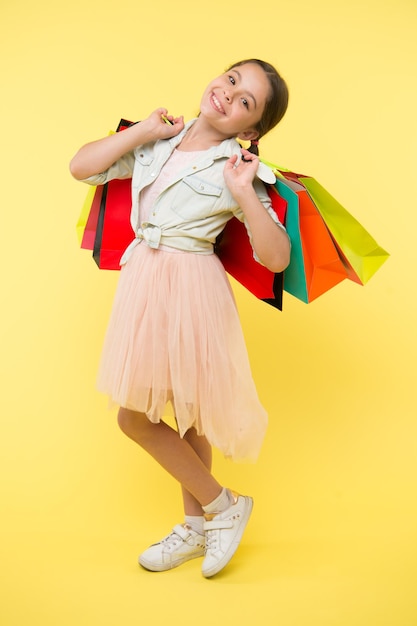 Niño en la tienda. niño feliz en la tienda con bolsas. hermosa niña niño en la tienda. concepto de tienda para niños. ir de compras es la mejor terapia.
