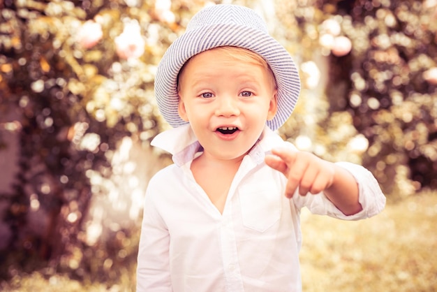 Foto niño tiene alegría de verano juego de niños al aire libre niño feliz de pie en la hierba en un día soleado de verano