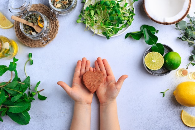 Foto niño tiene corazón de coco en las manos comida natural orgánica