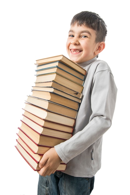 Foto niño tiene una pila de libros antiguos y sonriendo