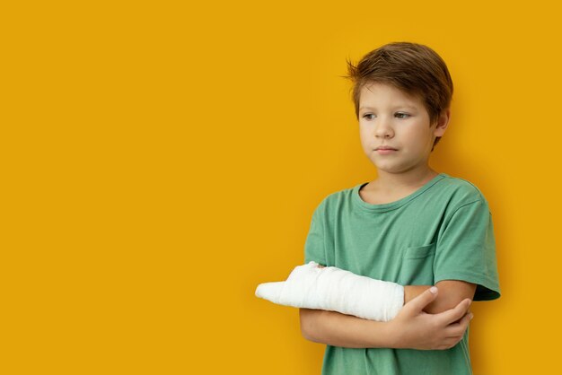 Un niño con una tirita en la mano. Copie el espacio.