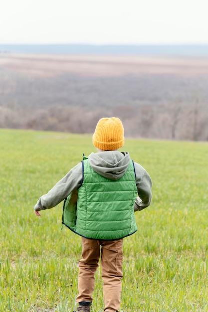 Niño de tiro completo caminando al aire libre