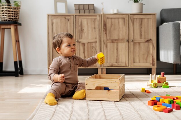 Niño de tiro completo jugando con caja de madera