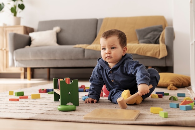 Foto niño de tiro completo jugando con juguetes en el interior