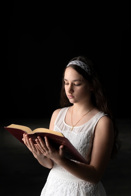 Niño de tiro medio leyendo la sagrada biblia