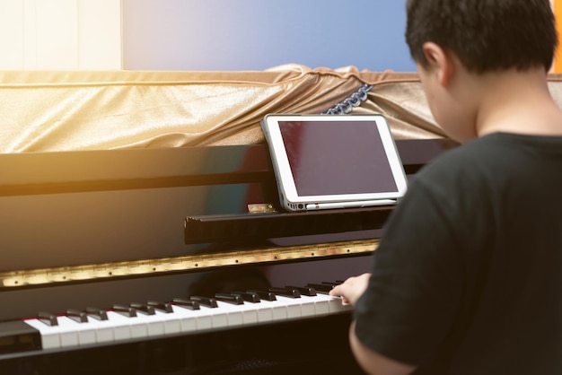 Niño toca el piano con aprendizaje en línea