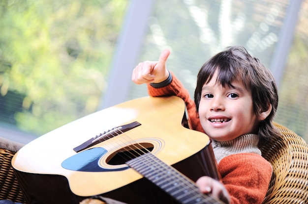 Niño tocando la guitarra en casa