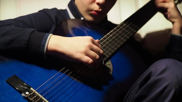 Foto un niño tocando una guitarra con una guitarra azul.