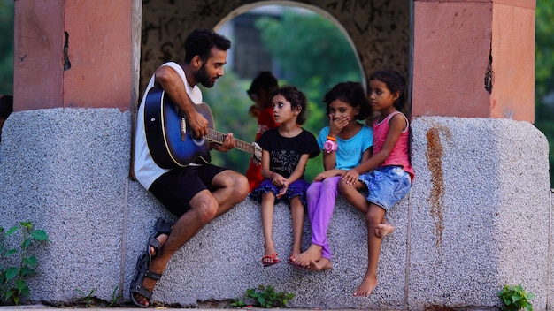 Niño tocando la guitarra con un niño pequeño