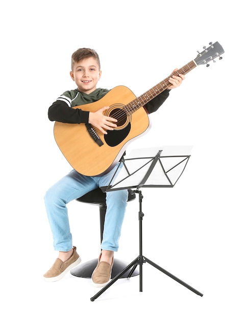 Niño tocando la guitarra en la superficie blanca