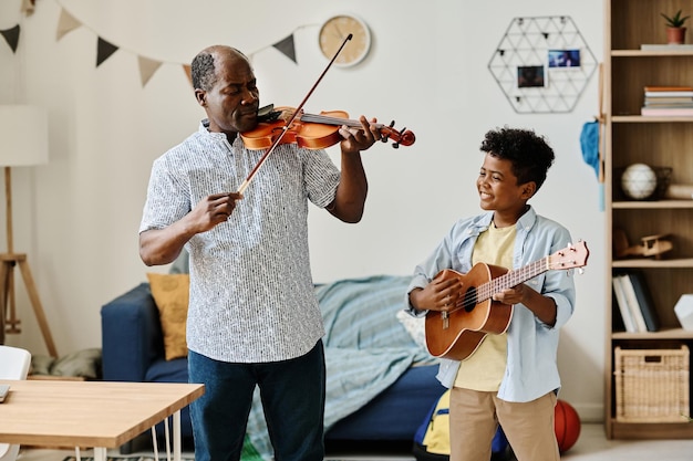 niño tocando instrumentos musicales con el maestro