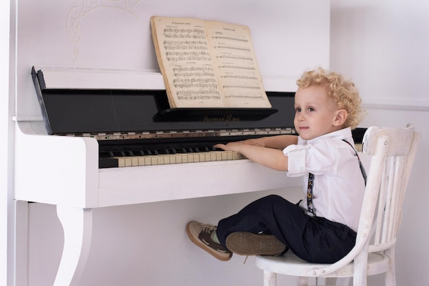 Foto niño tocando el piano en el interior