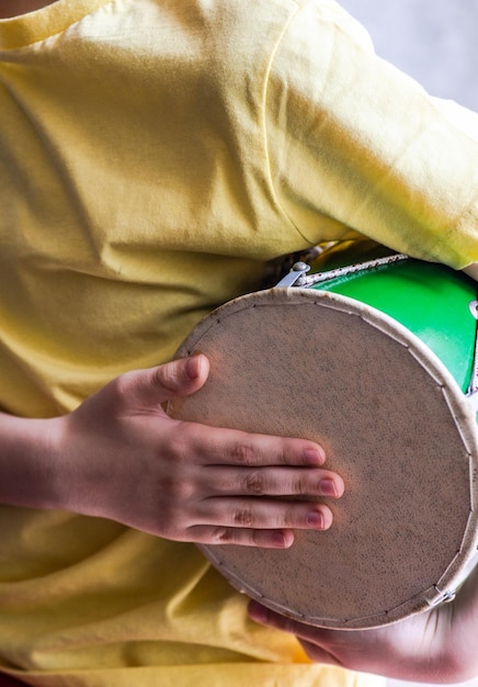 Foto niño tocando el tambor con las manos