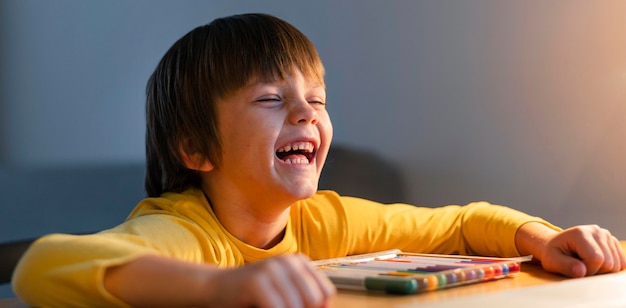 Foto niño tomando cursos virtuales y riendo.