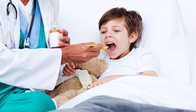 Foto niño tomando medicina para la tos