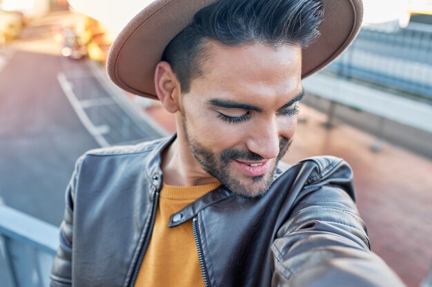 Niño tomando un selfie con sombrero y chaqueta de cuero