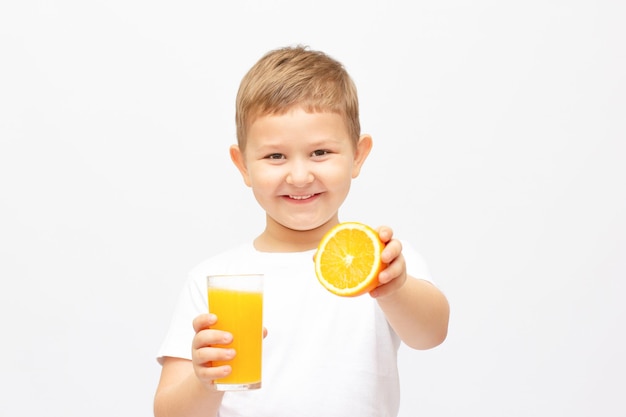 Niño tomando un vaso de jugo de naranja refrescante - aislado en blanco