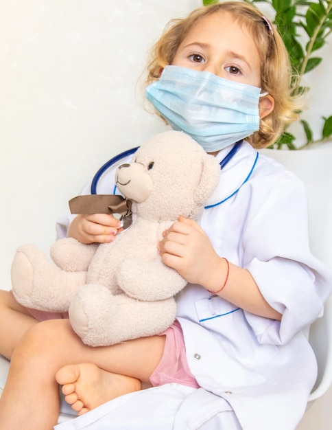 Un niño trata a un oso de peluche como a un médico enfoque selectivo