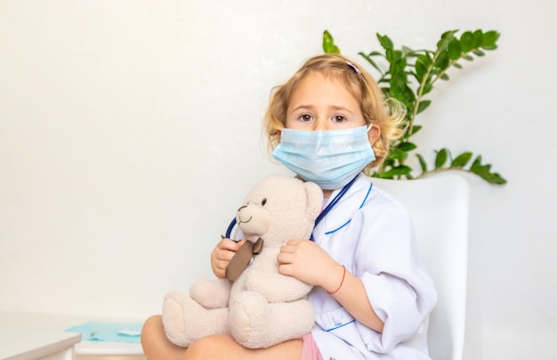 Un niño trata a un oso de peluche como a un médico enfoque selectivo
