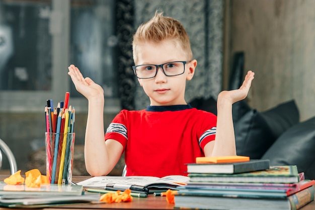 El niño está triste, aburrido de hacer la tarea.