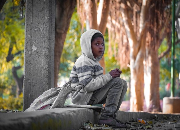 Niño triste solitario en el parque