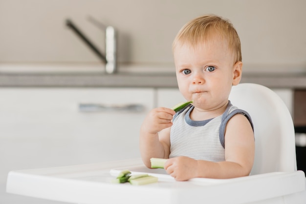 Foto niño en trona comiendo