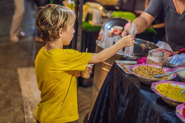 Niño turista en el mercado de comida asiática de Walking Street