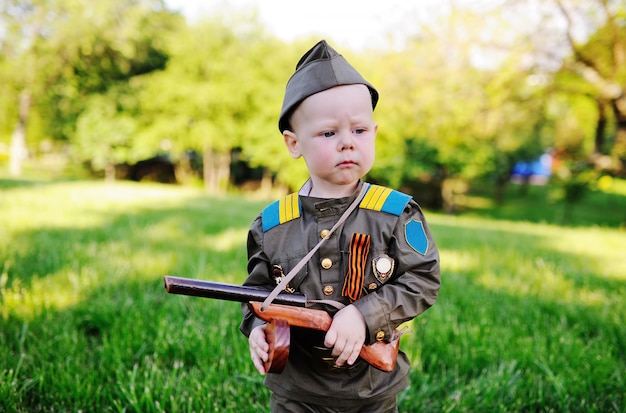 Niño en uniforme sobre fondo de árboles