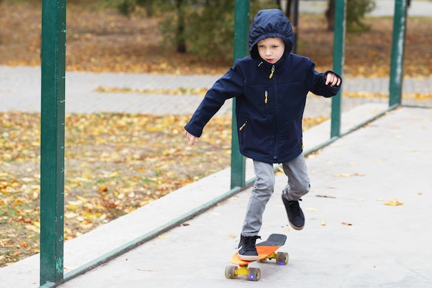 Niño urbano aprende a montar en una penny board