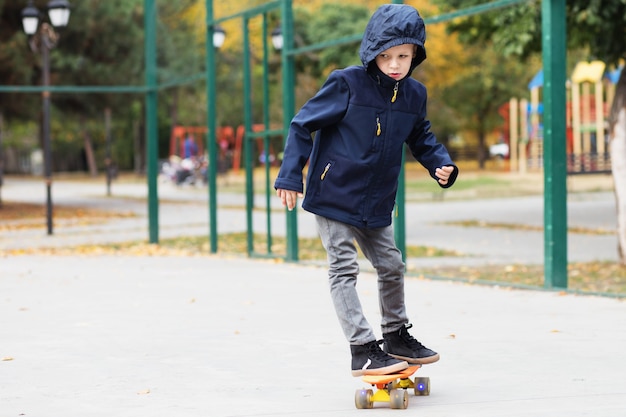 Niño urbano aprende a montar en una penny board