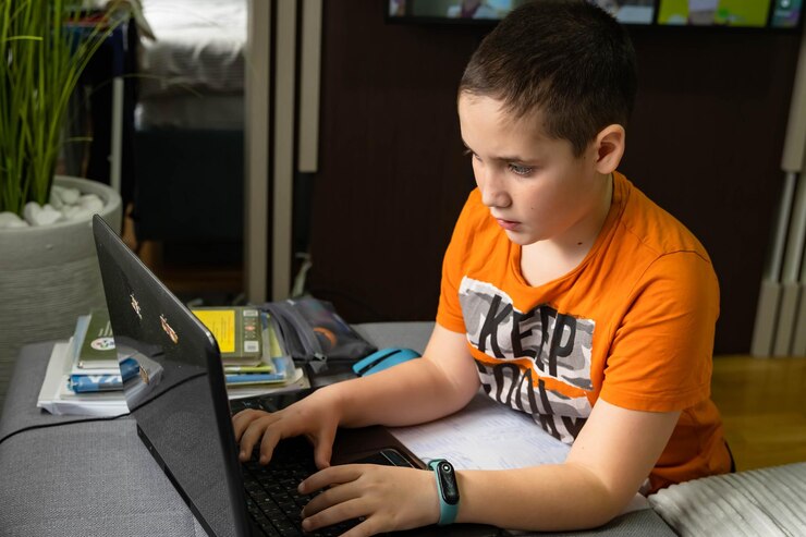 Foto niño usando una computadora portátil en casa