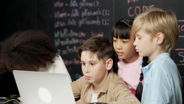 Niño usando una computadora portátil programando código de ingeniería y escribiendo programas Erudición