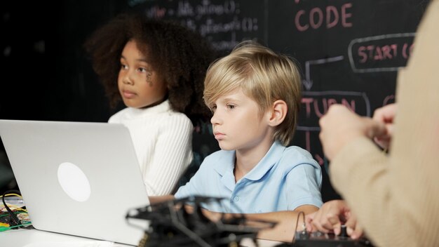 Foto niño usando una computadora portátil programando código de ingeniería y escribiendo programas de erudición