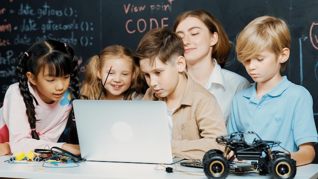 Niño usando una computadora portátil programando código de ingeniería y escribiendo programas Erudición