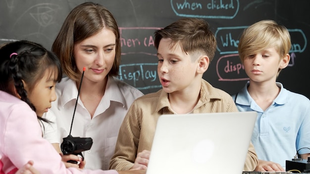 Niño usando una computadora portátil programando código de ingeniería y escribiendo programas de erudición