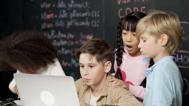 Niño usando una computadora portátil programando código de ingeniería y escribiendo programas de erudición