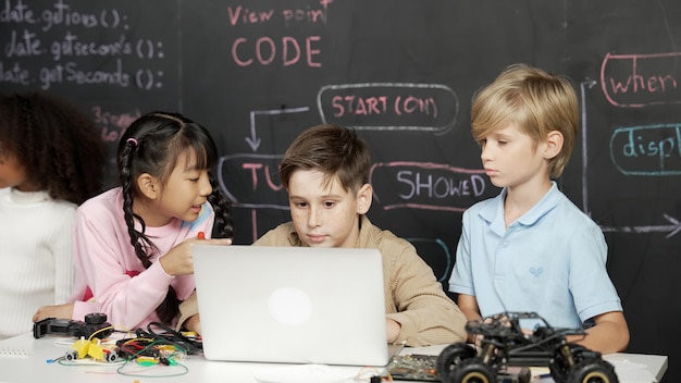 Niño usando una computadora portátil programando código de ingeniería y escribiendo programas de erudición