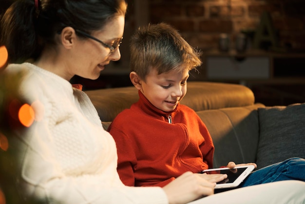 Niño usando una tableta con su madre