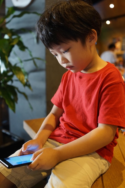 Niño usando teléfono inteligente en casa
