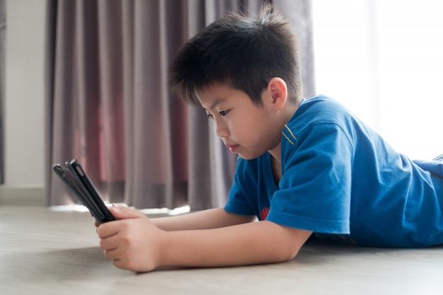 Niño usando teléfono inteligente en su habitación