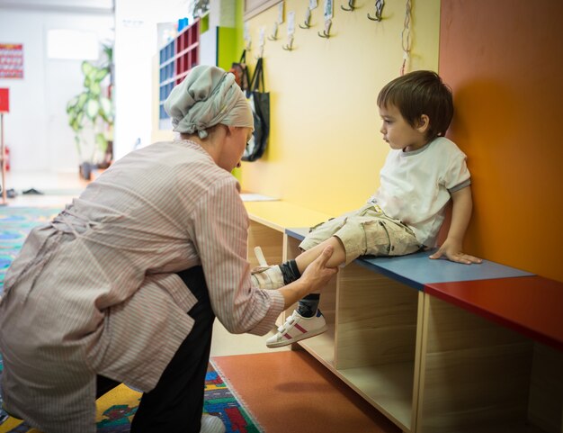 Foto niño usando zapatos y sentado