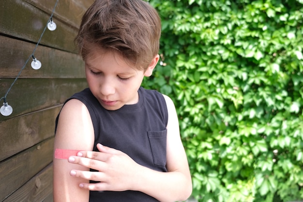 Foto niño vacunado contra la infección por coronavirus. vacunación contra covid-19. sputnik-v. copie el espacio.