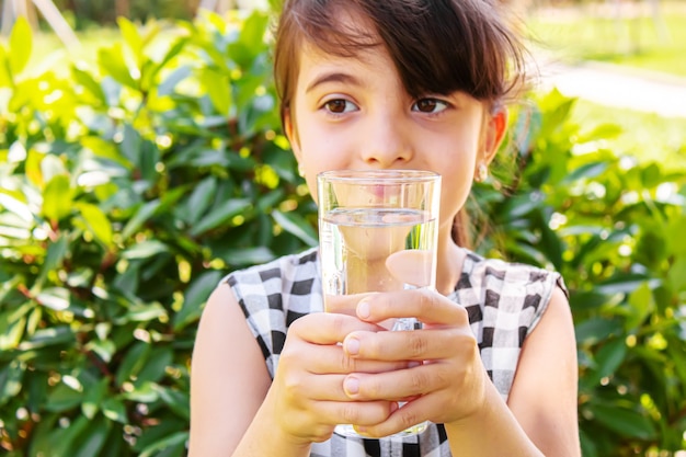 Niño vaso de agua. enfoque selectivo. Naturaleza de los niños