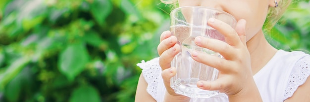 Niño vaso de agua. enfoque selectivo naturaleza.