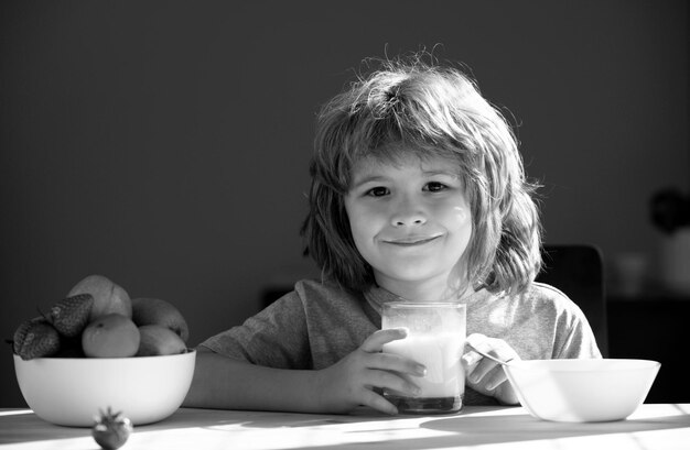 Niño con un vaso de leche comiendo alimentos saludables