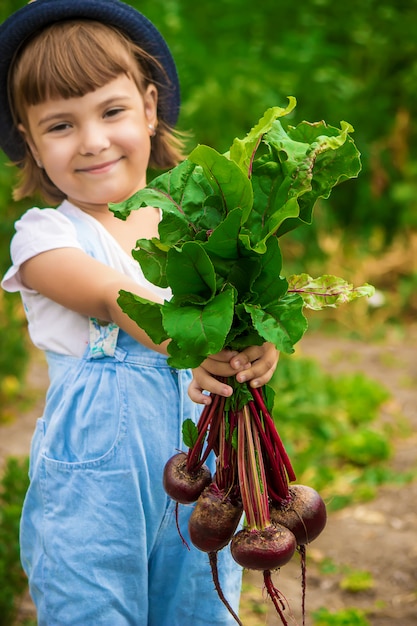 Niño y verduras en la granja. Enfoque selectivo